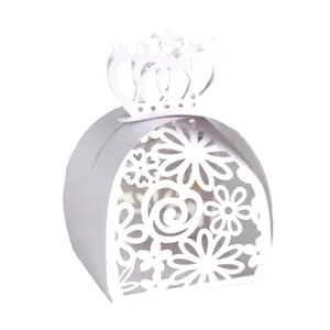 Close-up detail of white crown laser-cut paper wedding candy box with floral patterns