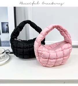 Fashionable quilted puffer cloud handbags in black and pink shown on a minimalist table