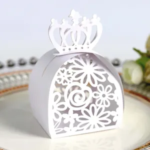 Close-up of a white laser-cut wedding candy box featuring an elegant crown and floral pattern