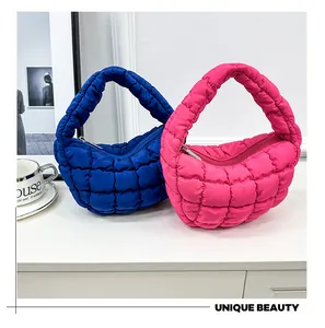 Close-up detail of quilted mini cloud underarm handbags in vibrant blue and pink.