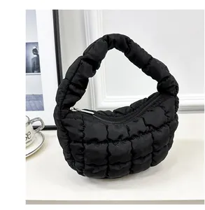 Close-up of black quilted cloud bag with unique puffy texture and secure zip closure