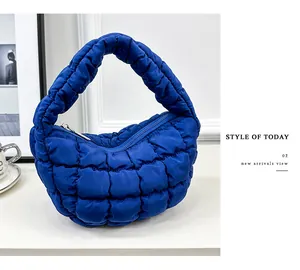 Close-up detailed view of the quilted texture on a blue stylish puffy cloud handbag