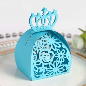 Detailed view of a laser-cut light blue wedding favor box with crown and floral pattern