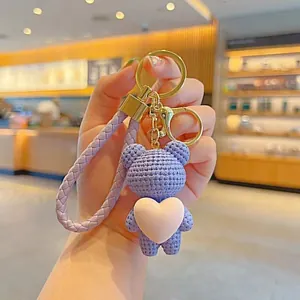 Handmade purple knitted bear keychain with pink heart and braided strap for bag decoration