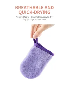 Close-up of a soft purple flannel makeup remover mitt held by a hand with a loop.