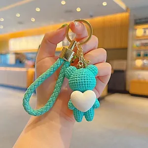 Woven turquoise bear keychain with white heart charm and gold-tone ring
