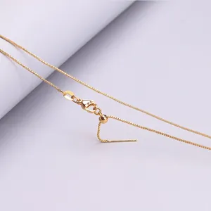 Detailed view of adjustable gold box chain with slider bead and needle end.