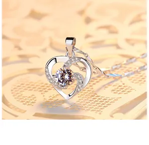 Gros plan d'un collier avec pendentif cœur rotatif et pierres en zircon cubique.