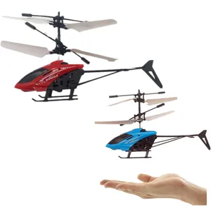 Red and blue induction helicopter toys hovering above a hand showing flight control