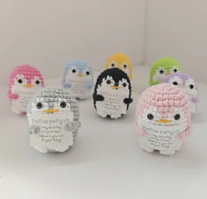 Collection of colorful handmade crochet penguins with tiny positive affirmation greeting cards.