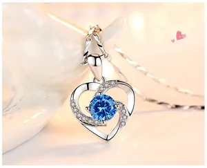 Gros plan du pendentif en forme de cœur avec pierre bleue et accents pavés