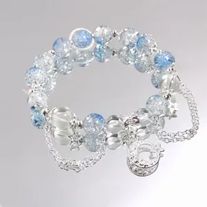 Close-up of blue cracked crystal beaded bracelet with silver moon and star charms