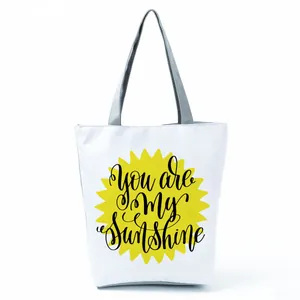 Stylish white tote bag with yellow sun graphic and You are My Sunshine lettering.