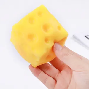 Yellow cheese-shaped TPR soft squeeze toy for effective stress relief, shown being squeezed in hand