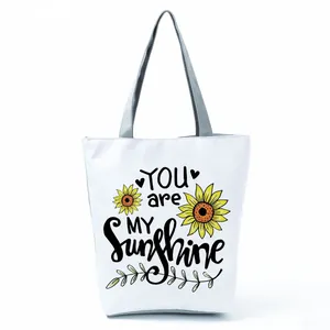 White canvas tote bag featuring sunflower print and You are my sunshine design