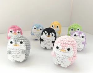 Close-up of handmade crochet positive penguins in various colors with cards