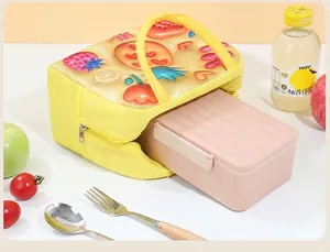 Detailed view of yellow insulated lunch bag with fruit patterns and pink bento box inside