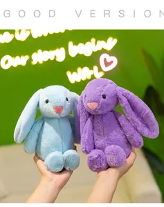 Close-up detail of cute soft long-eared plush rabbit dolls in vibrant blue and purple