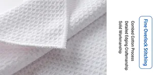 Macro view of white waffle weave microfiber golf towel with detailed overlock stitching