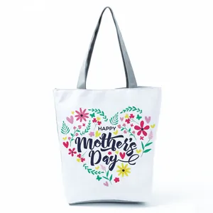 Detailed view of floral heart pattern and Happy Mother's Day print on white tote bag