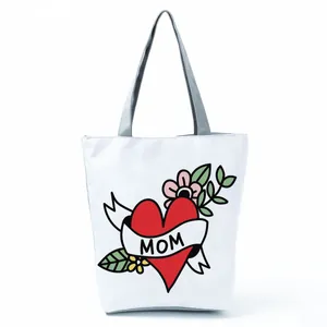 White canvas tote bag featuring a classic red heart and MOM banner tattoo design
