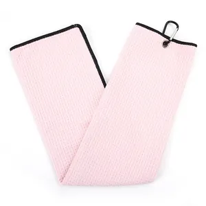 Close-up of pink microfiber waffle weave golf towel with black carabiner clip.