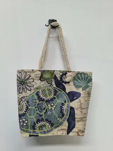 Detail of beach tote bag featuring turtle print and nautical rope handles.