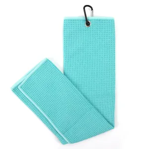Close-up of microfiber golf towel with waffle weave texture and black carabiner clip
