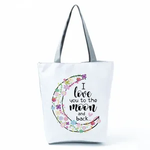Detailed view of the floral crescent moon and quote print on a white canvas tote bag