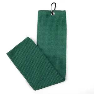 Detailed macro view of a green waffle weave microfiber golf towel with black carabiner