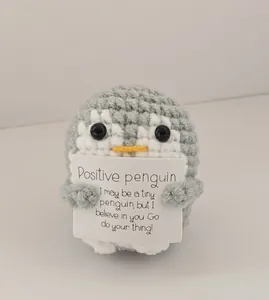 Handmade crochet positive penguin doll holding a motivational quote message card