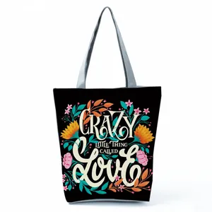 Detailed view of the vibrant floral and letter print on a stylish black canvas tote bag