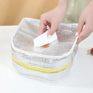 Insulated lunch bag with thick aluminum foil lining being wiped clean for easy maintenance
