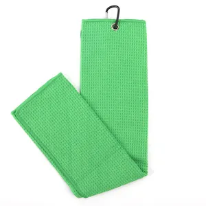 Green microfiber waffle weave golf towel detail featuring a black carabiner clip