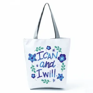 White tote bag detail with blue floral print and 'I CAN and I will' motivational quote.