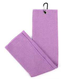 Detailed view of purple microfiber golf towel featuring waffle weave and black carabiner