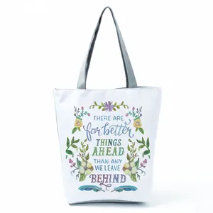 Detail of white canvas tote bag with floral print and motivational English quote