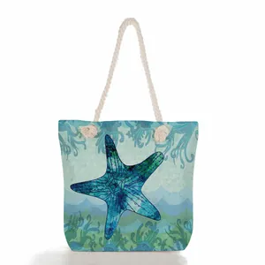 Detailed view of the starfish print and rope handle on this large beach tote bag.