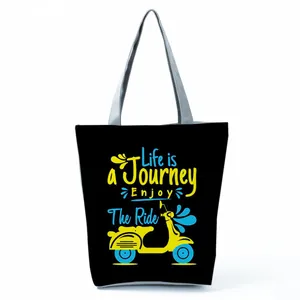 Detailed view of black tote bag with vibrant Life is a Journey scooter graphic print