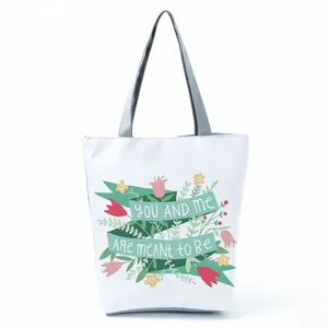 Detailed view of floral patterns and romantic text print on a white canvas tote bag