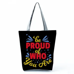 Detailed view of the colorful be PROUD of WHO You Are print on the black tote bag.