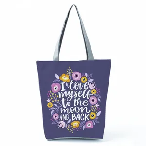 Detailed view of purple tote bag featuring floral print and inspirational quote