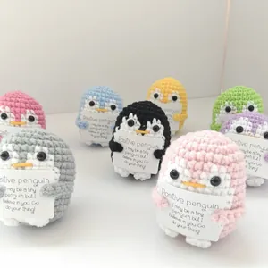 Group of colorful handmade crochet penguins holding positive encouragement cards