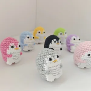 Set of colorful hand-crocheted positive penguins with encouraging handmade cards