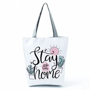 White tote bag featuring 'Stay at home' lettering and cute cartoon plant illustrations