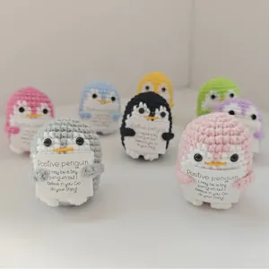 Handmade crochet positive penguins in multiple colors holding motivational cards