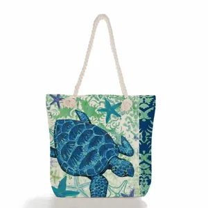Detailed view of the sea turtle print and rope handles on this large beach tote bag.