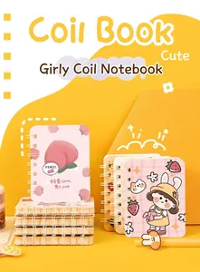 Close-up of cute A7 side-flip coil notebooks with peach and cartoon girl designs