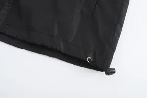 Detailed macro view of the adjustable drawstring hem on a black men's hooded jacket