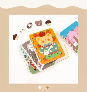 Macro view of mini A7 spiral notebooks featuring colorful cartoon bear and cherry blossom designs